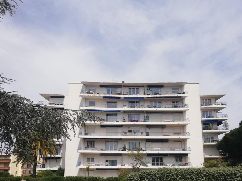 a white apartment building with balconies on it at Appartement Saint Raphaël in Saint-Raphaël