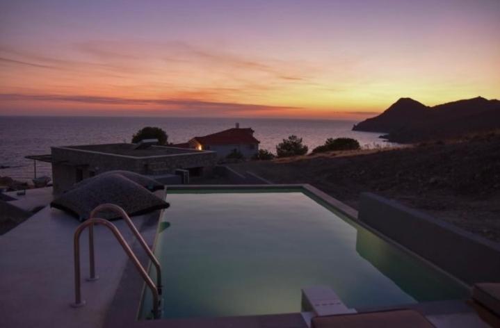 a swimming pool with a view of the ocean at sunset at JN VILLA in Agios Ioannis Kaspaka