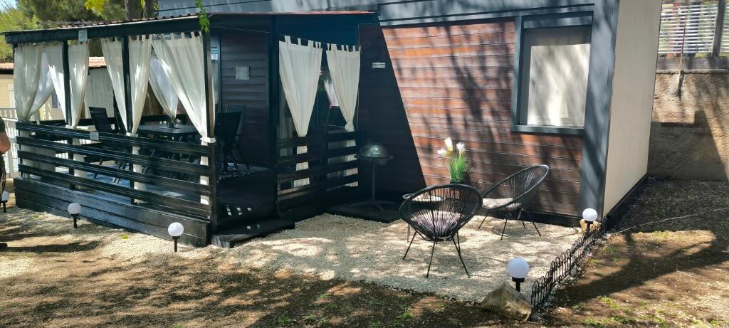 a black shed with two chairs and a table at Mobile home Ivan Vodice in Vodice