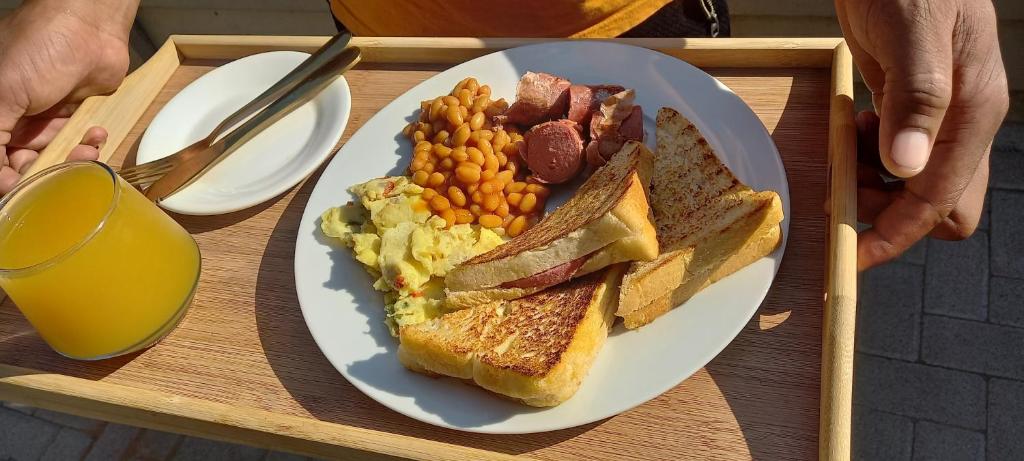 a plate of breakfast food on a wooden tray at Shiloh Shared in Gaborone