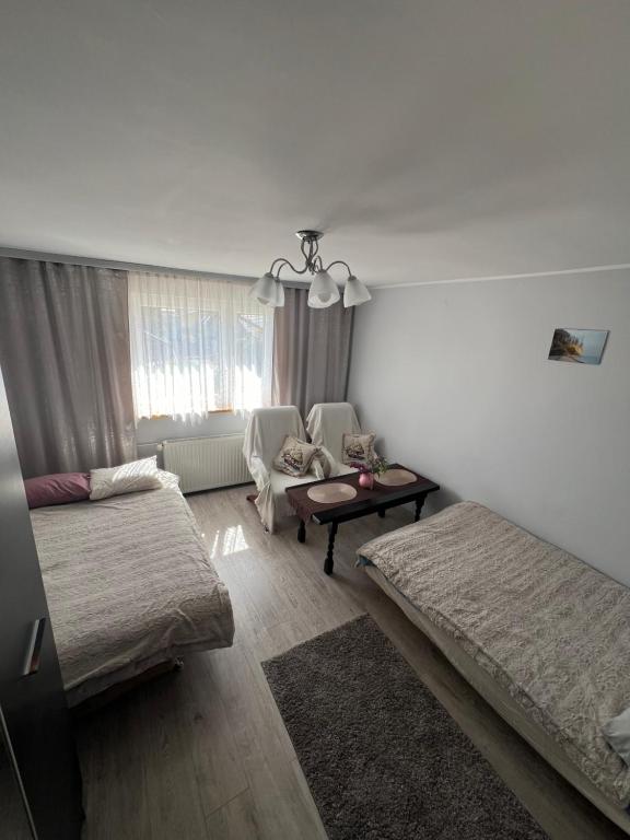 a living room with two beds and a table at Apartament Kackówka in Gdynia