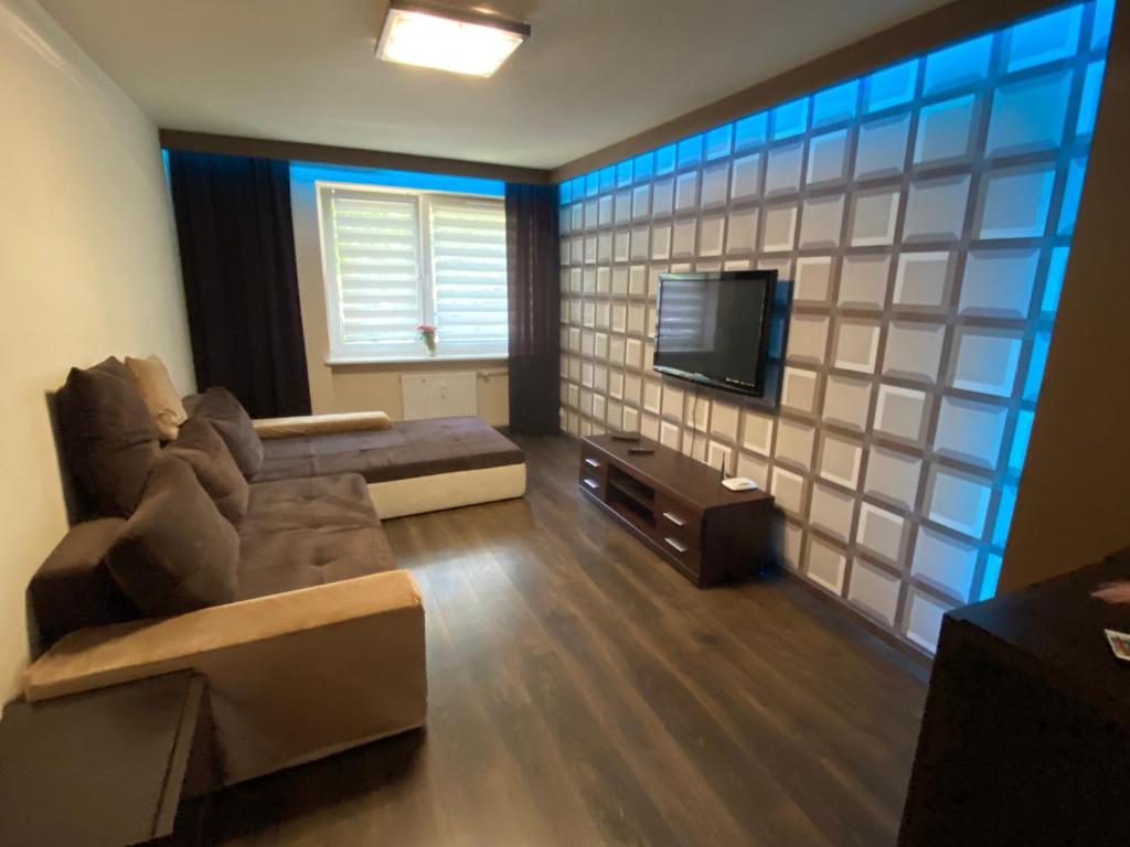 ein Wohnzimmer mit einem Sofa und einem Flachbild-TV in der Unterkunft Apartament Aleja 57 in Częstochowa