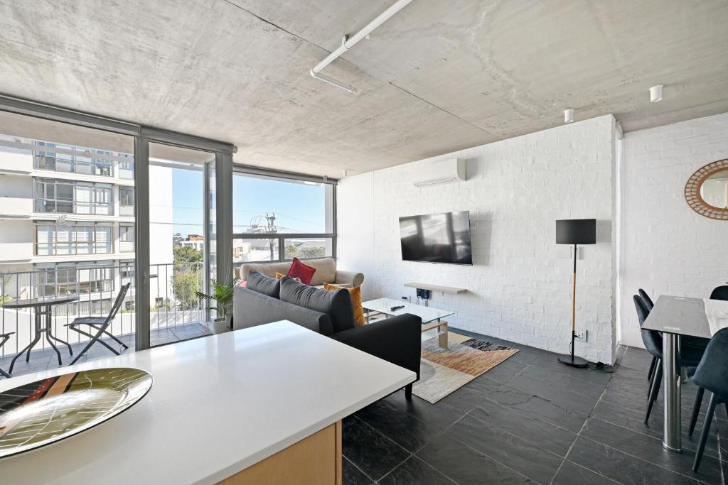 een woonkamer met een bank en een tafel bij Modern Living Mountain&ocean View 100m To Beach in Kaapstad