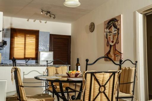 tavolo e sedie in cucina con un'immagine appesa al muro di Sunset Green 03 a Paphos