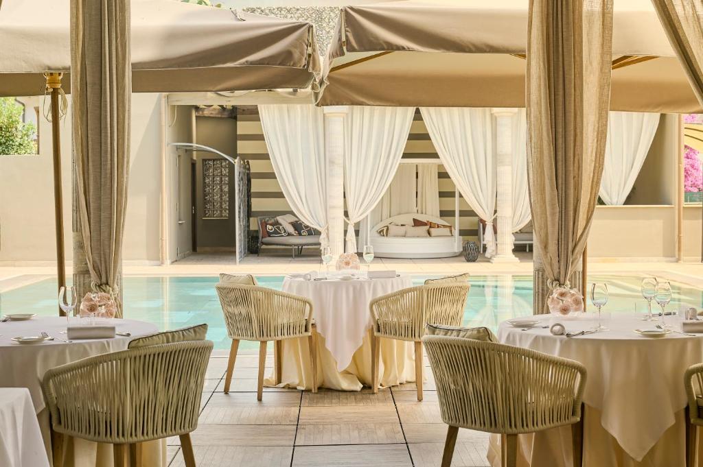 a restaurant with tables and chairs and a pool at Grand Hotel Imperiale in Forte dei Marmi