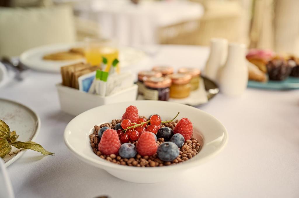 a bowl of berries on a white plate on a table at Grand Hotel Imperiale in Forte dei Marmi