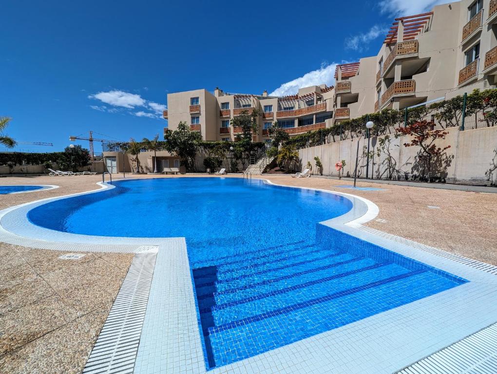 una piscina en un complejo con edificios de fondo en Flat in La Tejita, Médano, en Granadilla de Abona