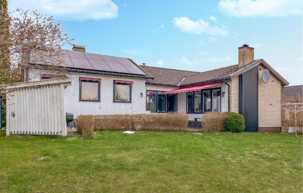 a white house with a fence in a yard at Amazing Home In Enhörna With Sauna in Enhörna