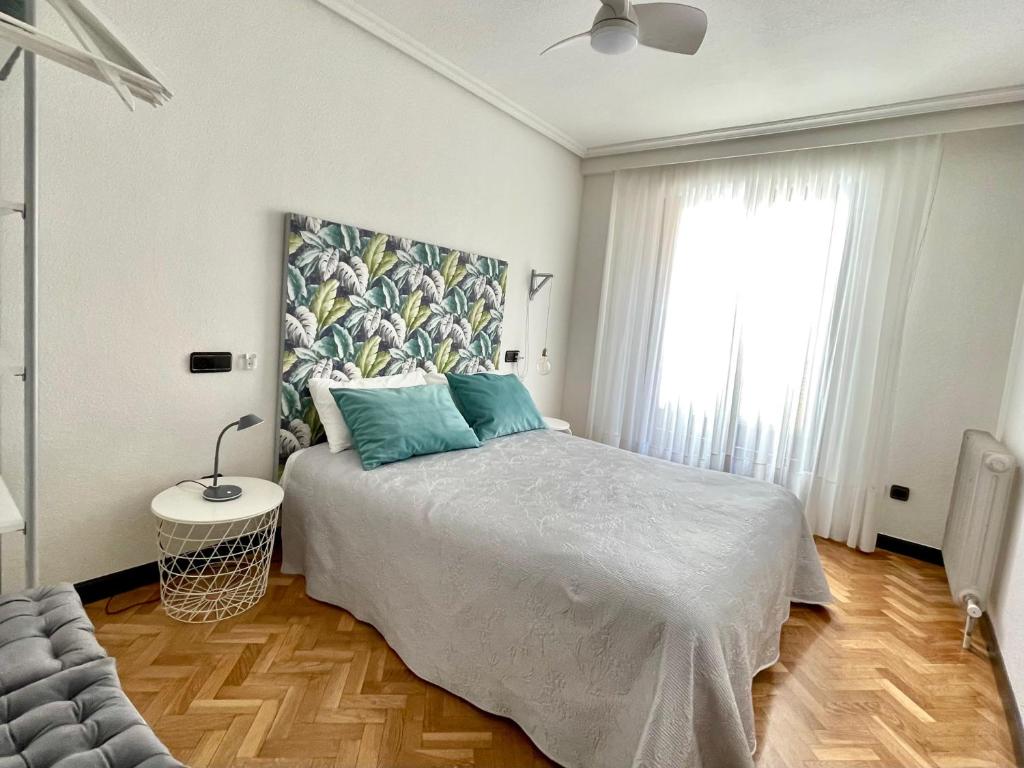 a bedroom with a bed and a large window at Vivienda con Parking incluido - Zona Van Dyck in Salamanca