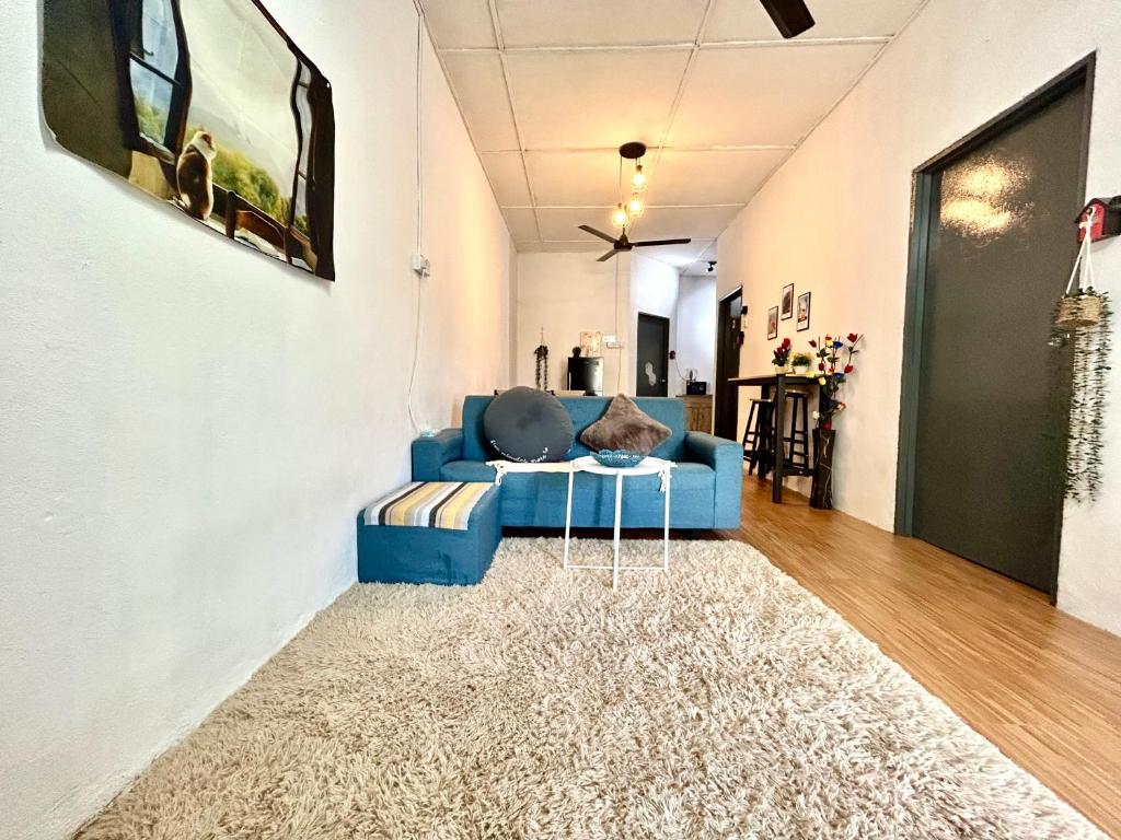 a living room with a blue couch and a rug at Cozy 18 Entire 3 Bedroom @Alma Bukit Mertajam in Bukit Mertajam