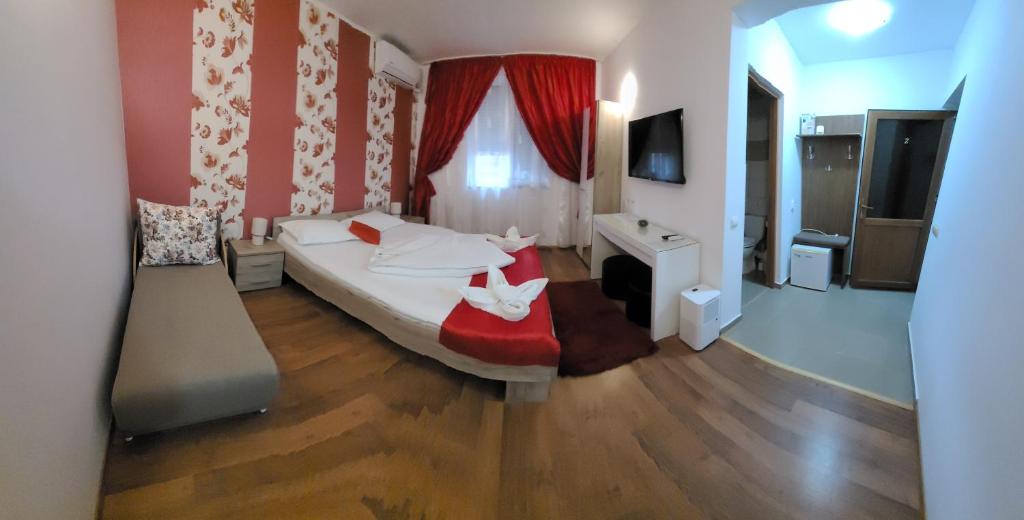 a bedroom with a large bed with a red wall at Casa Diana in Sulina