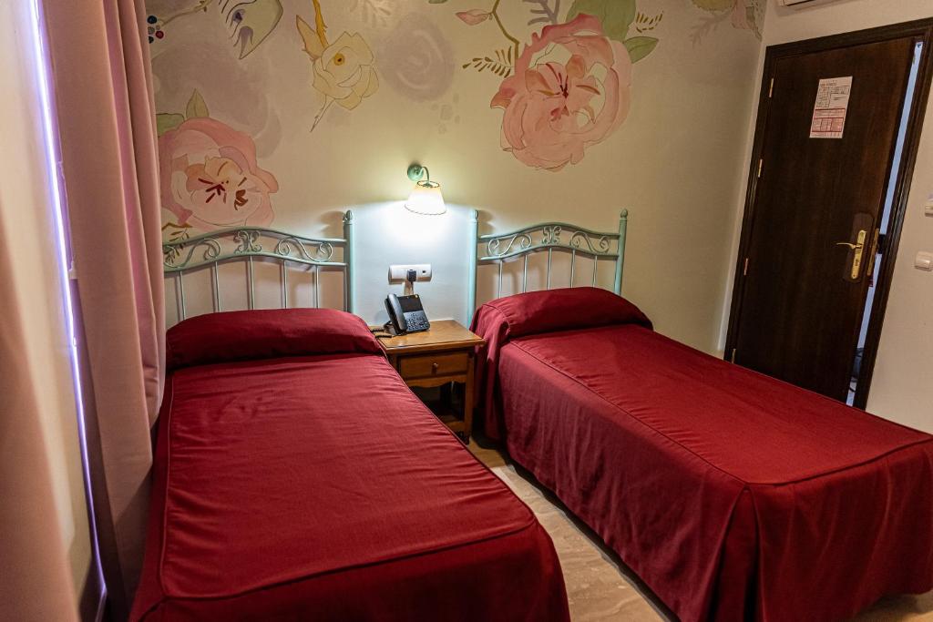 Łóżko lub łóżka w pokoju w obiekcie Hotel Las Rosas