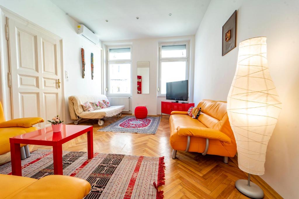 een woonkamer met oranje meubels en een televisie bij Anett's downtown apartment in Boedapest