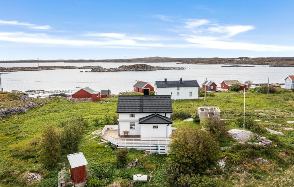 a group of houses in a field with a body of water at Cozy Home In Norddyry With Kitchen in Sætra