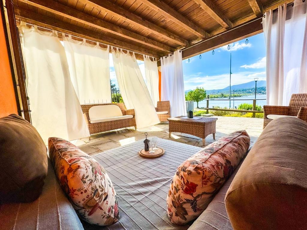 Una sala de estar con un sofá y una ventana grande. en Villa Riflessi - Manerba del Garda - by tourquoisevea, en Manerba del Garda