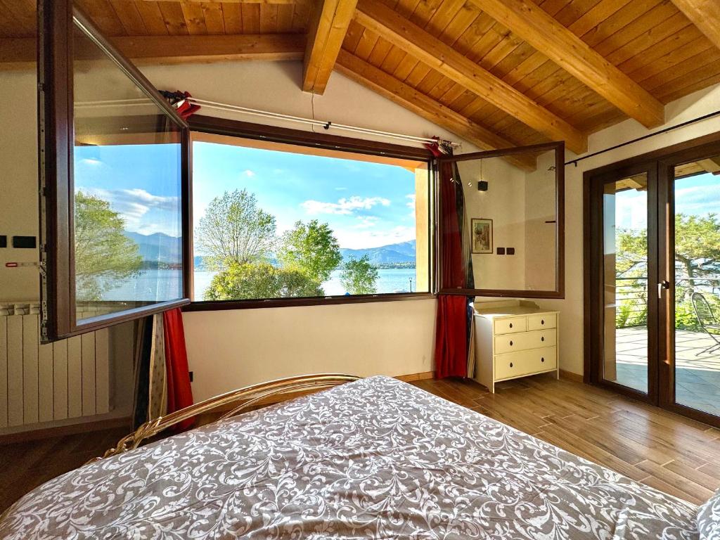 - une chambre avec un lit et une grande fenêtre dans l'établissement Villa Riflessi - Manerba del Garda, à Manerba del Garda