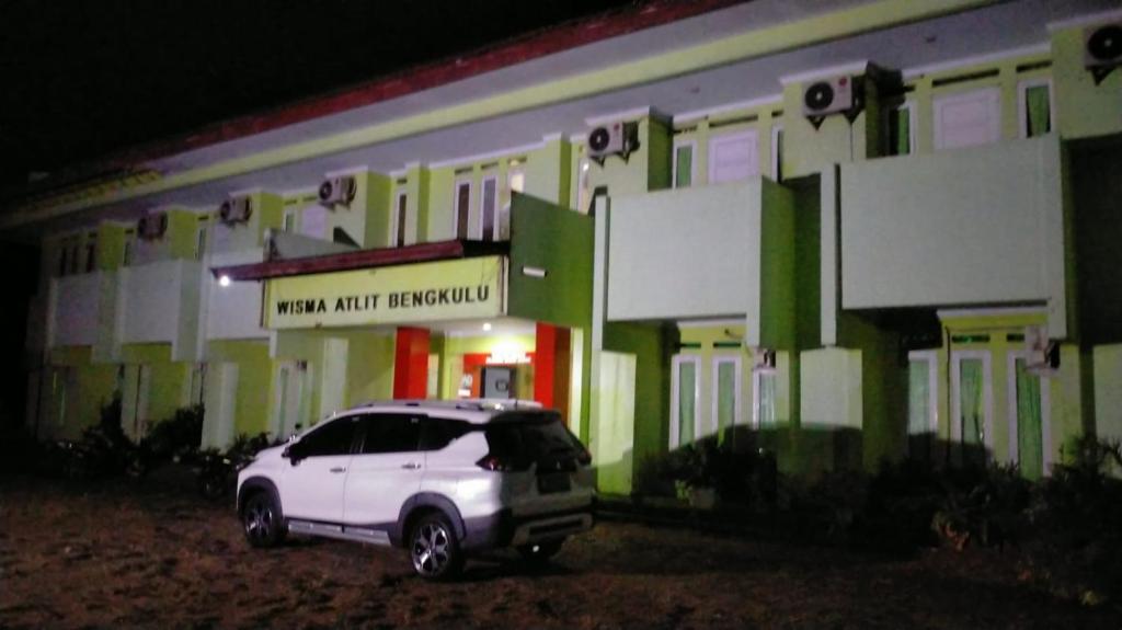 un coche blanco estacionado frente a un edificio en Hotel Grand Atlet Bengkulu en Bengkulu