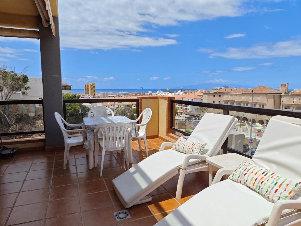 een balkon met een tafel en stoelen en uitzicht bij 1-bedroom apartment with big terrace and ocean view in Los Cristianos in Los Cristianos