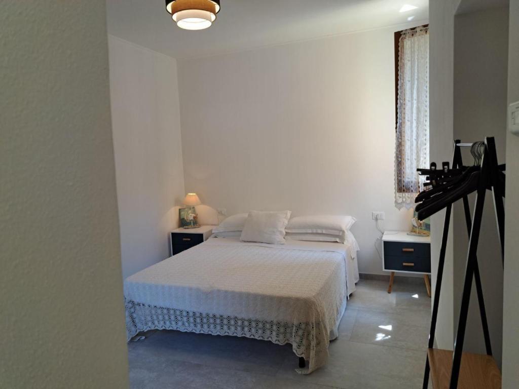 - une chambre blanche avec un lit et une caméra dans l'établissement Affittacamere Sophie, à Monterosso al Mare