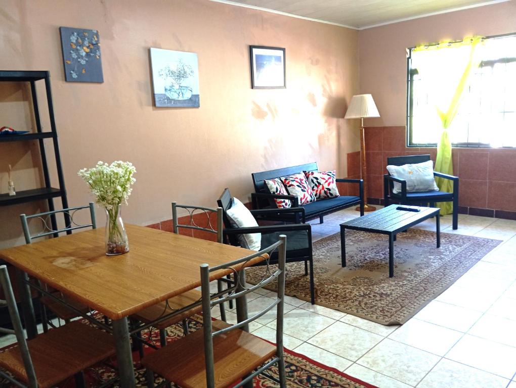 sala de estar con mesa y sofá en Cabinas Miramar, una casa SOLO para ti, en San Isidro