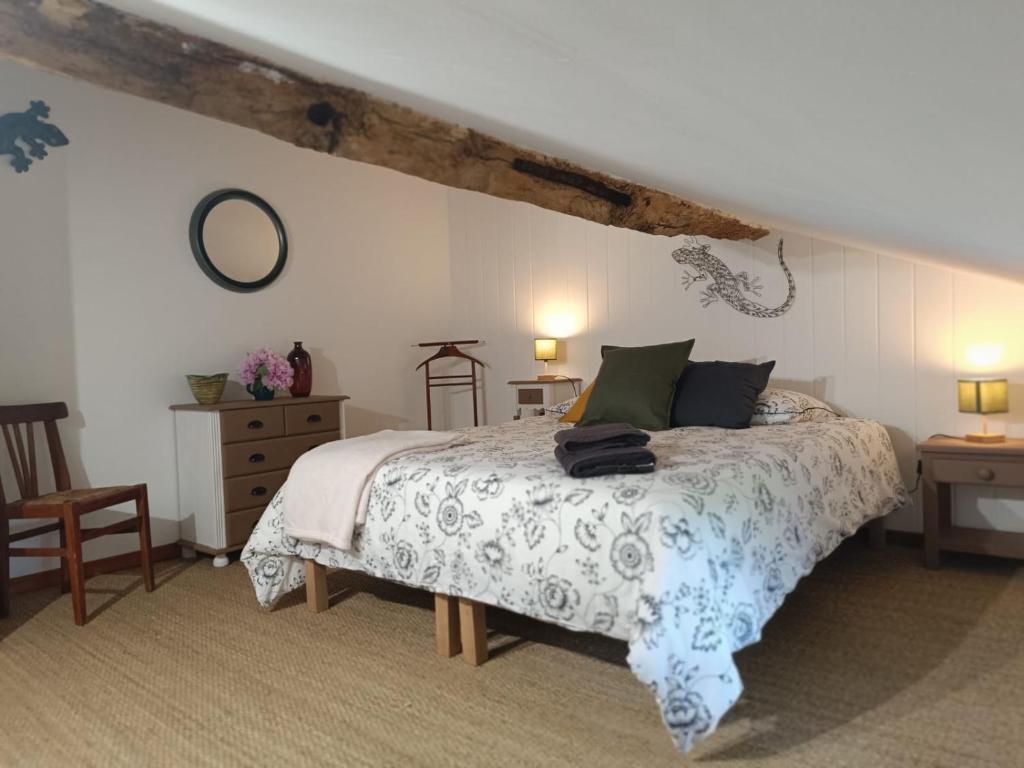 a bedroom with a bed and two tables and a chair at Maison d'HÔTES LA FEZENDES in Miradoux