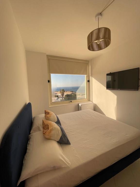 a bedroom with a large bed with a window at Puglia Dreaming seaview apartment in Polignano a Mare