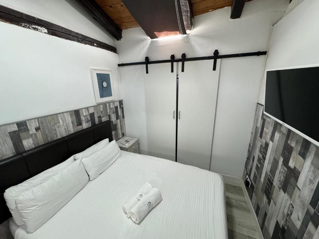 Un dormitorio con una cama blanca con una toalla. en Apartamentos Day Madrid SILVA Centro Gran Via Sol Malasaña, en Madrid