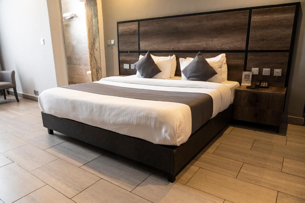 a large bed with a large headboard in a room at The Blowfish Hotel in Lagos