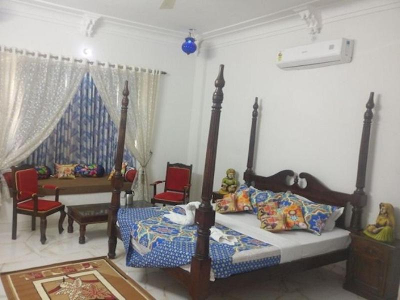 1 dormitorio con 1 cama, mesa y sillas en Tej Mahal Palace, en Bandikui