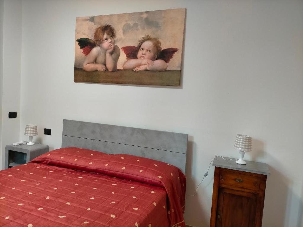 um quarto com uma cama e um quadro na parede em CASA ELGA em Borgo a Buggiano