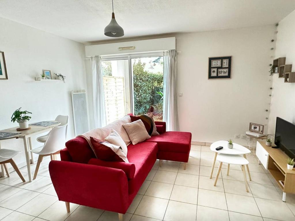 un salon avec un canapé rouge et une table dans l'établissement Appartement T2 confortable à Cambo-les-Bains - Terrasse, Parking, Animaux Ok, Internet - FR-1-495-128, à Cambo-les-Bains