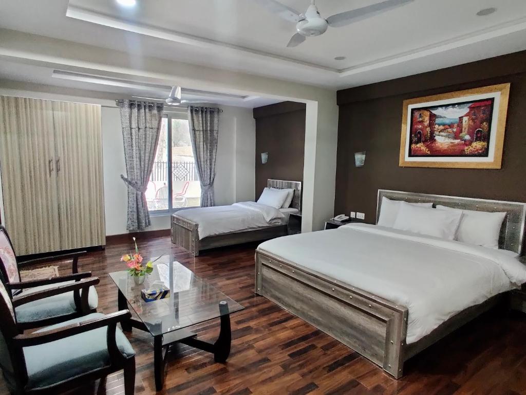 ein Hotelzimmer mit einem Bett, einem Sofa und einem Tisch in der Unterkunft Safina Hotel Skardu in Skardu