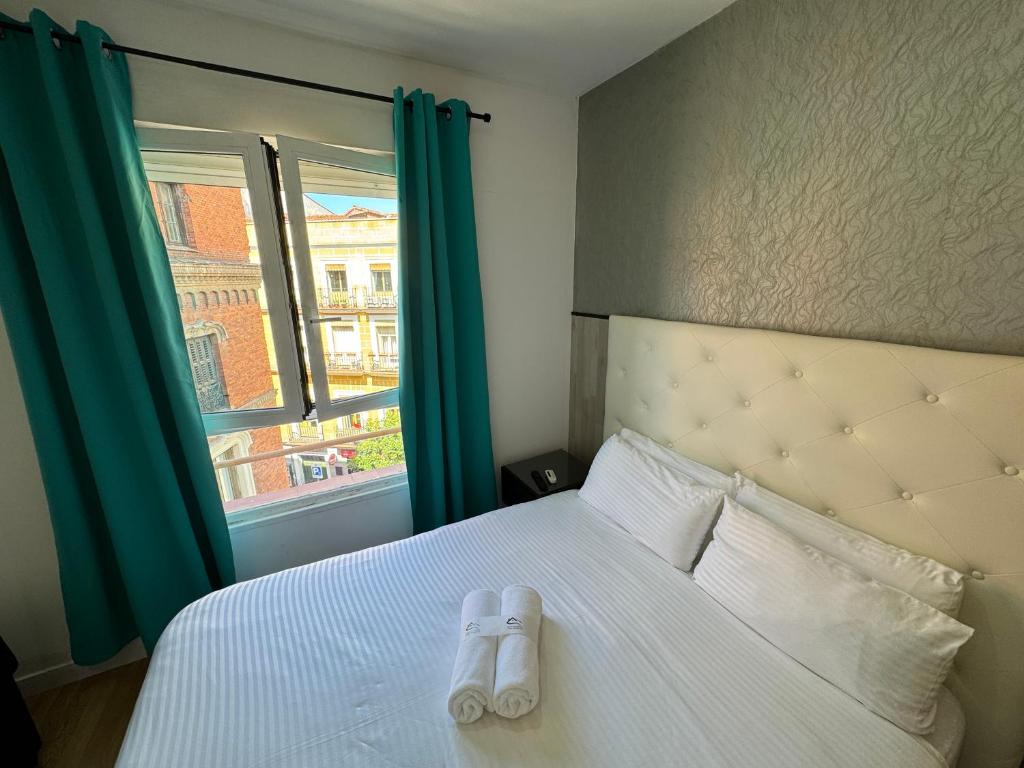 a bed with a pair of shoes sitting on it w obiekcie Apartamentos Day Madrid BALLESTA Centro Gran Via Sol Malasaña w Madrycie