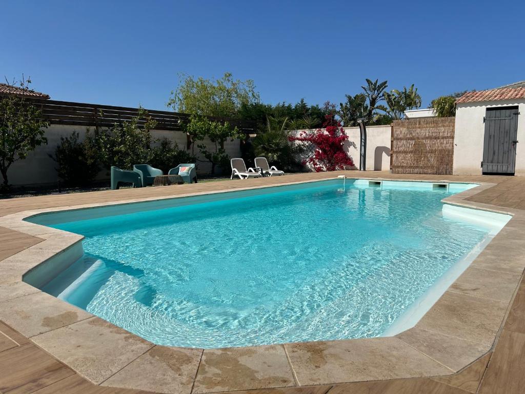 una piscina de agua azul en un patio en Très belle villa avec piscine chauffée CASALEONI, en Prunelli-di-Fiumorbo