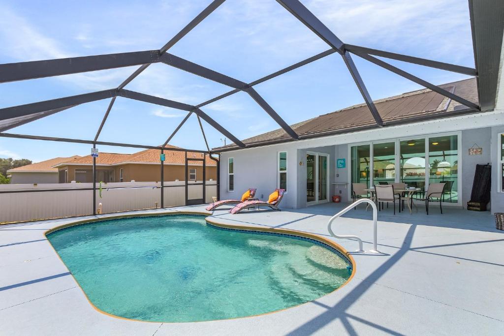 una piscina con un gran techo de cristal en Pool Table & Game Room, Solar Heated Pool, A Perfect Rest - Villa The Getaway - Roelens, en Cabo Coral