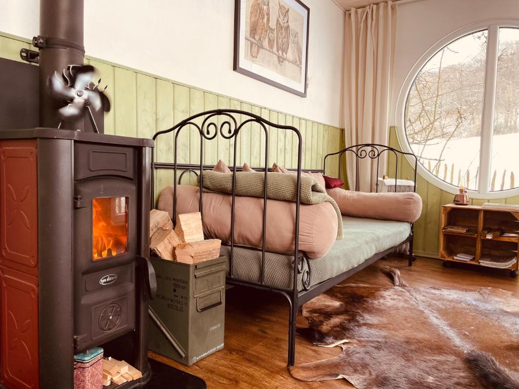 a bedroom with a bed and a wood stove at Eulennest - Tiny House im Habichtswald in Schauenburg