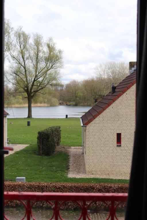 - une vue depuis la fenêtre d'un bâtiment et d'un champ dans l'établissement Comfortabel 6p vakantiehuis met laadpaal, à Ewijk