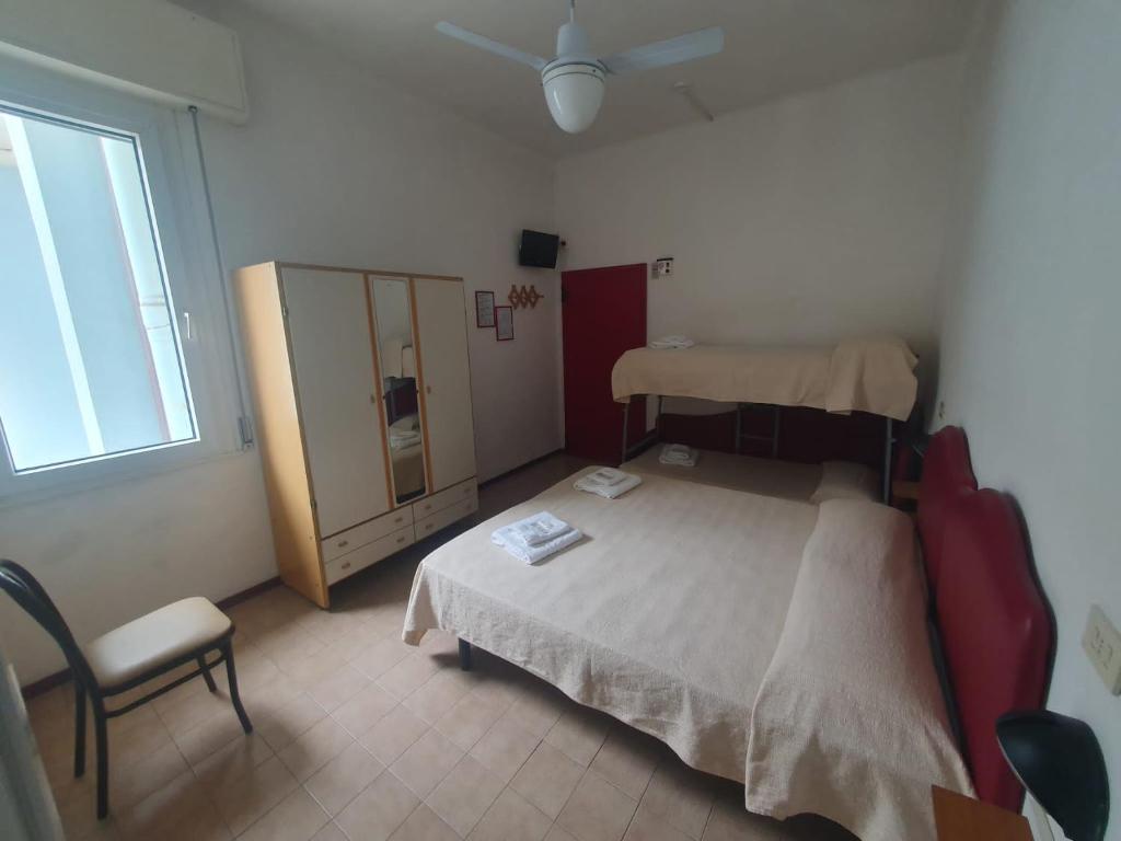 - une chambre avec un lit, une chaise et une fenêtre dans l'établissement HOTEL IDEALE young people under 40, à Rimini