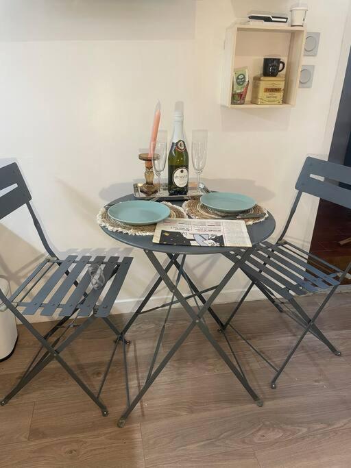 une table avec deux chaises, une bouteille et des verres dans l'établissement Découvrez Marseille depuis le Panier - Solo/Duo, à Marseille