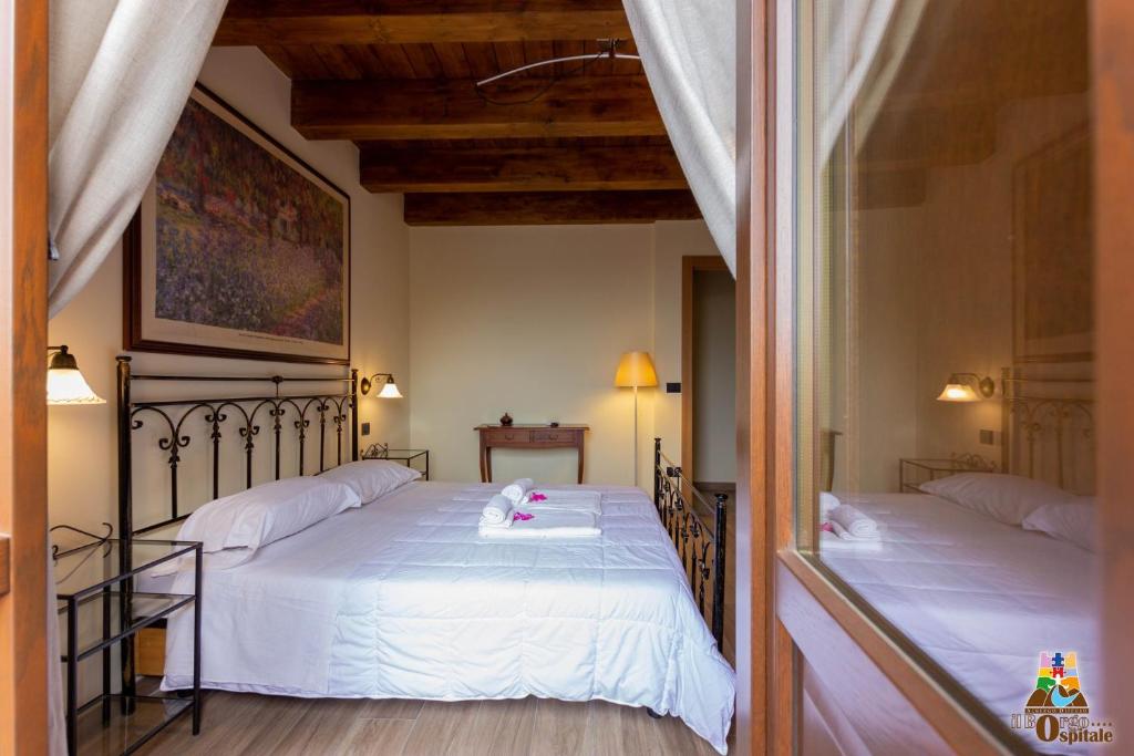 a bedroom with two beds with white sheets at Il Borgo Ospitale - Albergo Diffuso in Rotonda