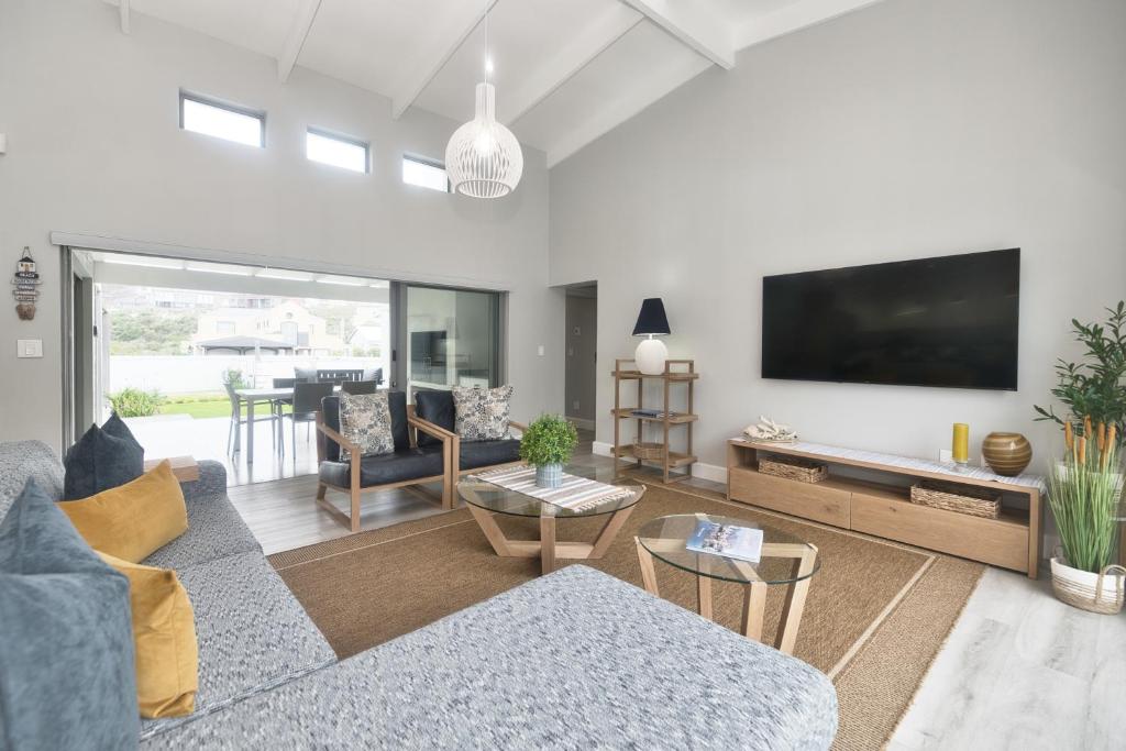 un soggiorno con divano e TV a schermo piatto di Cliff Haven a Struisbaai