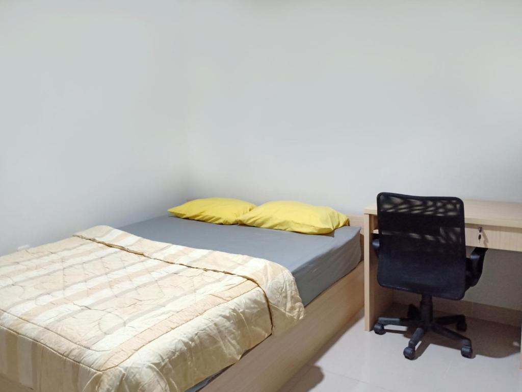 Schlafzimmer mit einem Schreibtisch, einem Bett und einem Stuhl in der Unterkunft Kost Mandala Residence Official (Syariah) in Jakarta