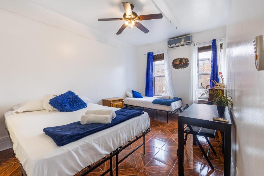 a bedroom with two beds and a ceiling fan at KLO Guest House in Brooklyn