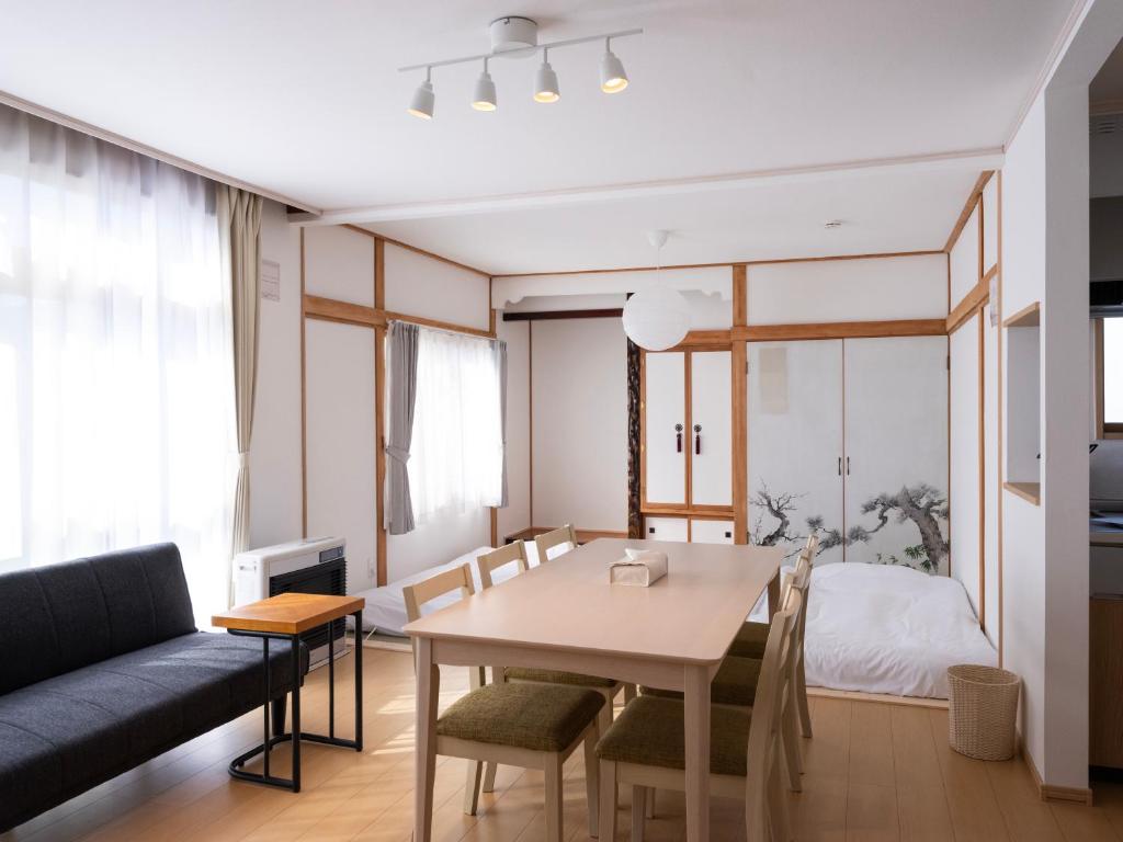 富良野的住宿－FURANO BnB，客厅配有桌子和沙发