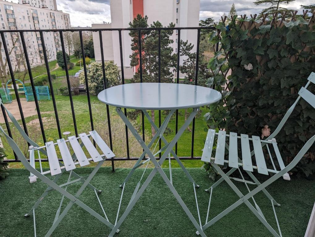 d'une table en verre et de deux chaises sur un balcon. dans l'établissement Paris Access with Creteil Apartment, à Créteil