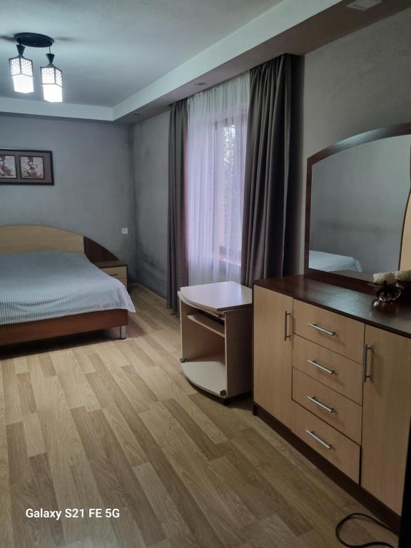 a bedroom with a bed and a dresser and a mirror at Happy 1 in Tbilisi City