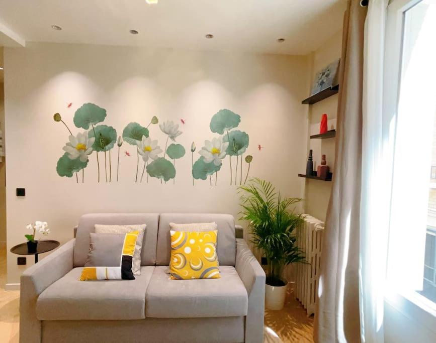 - un canapé dans le salon orné d'une peinture murale dans l'établissement Appart close to Eiffel Tower, à Paris