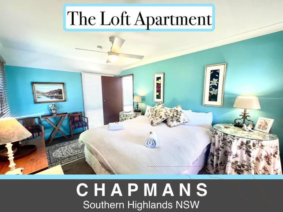 una habitación con una cama y un cartel que lee los capítulos del apartamento en French Boutique Loft Apartment @Chapmans+breakfast, en Moss Vale