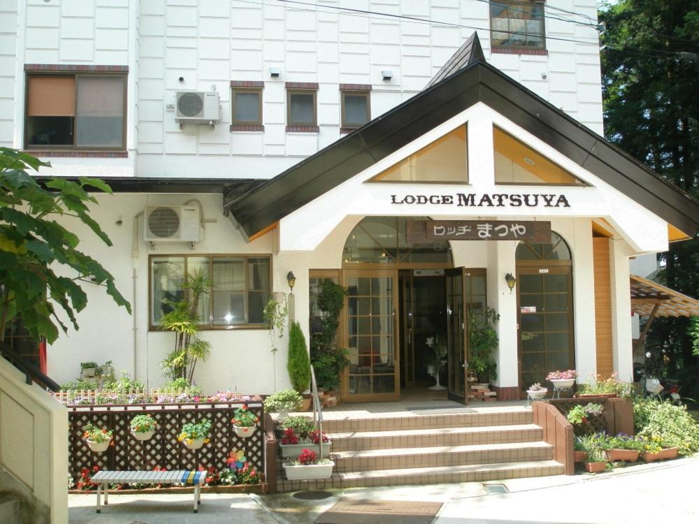野澤溫泉的住宿－松山旅館，带有松散的马来石标志的建筑