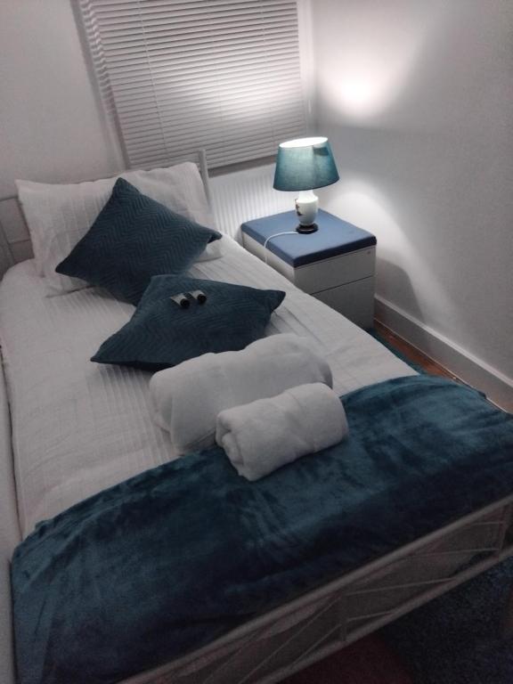 1 cama con manta azul y almohadas en Casa Brillo, en Londres